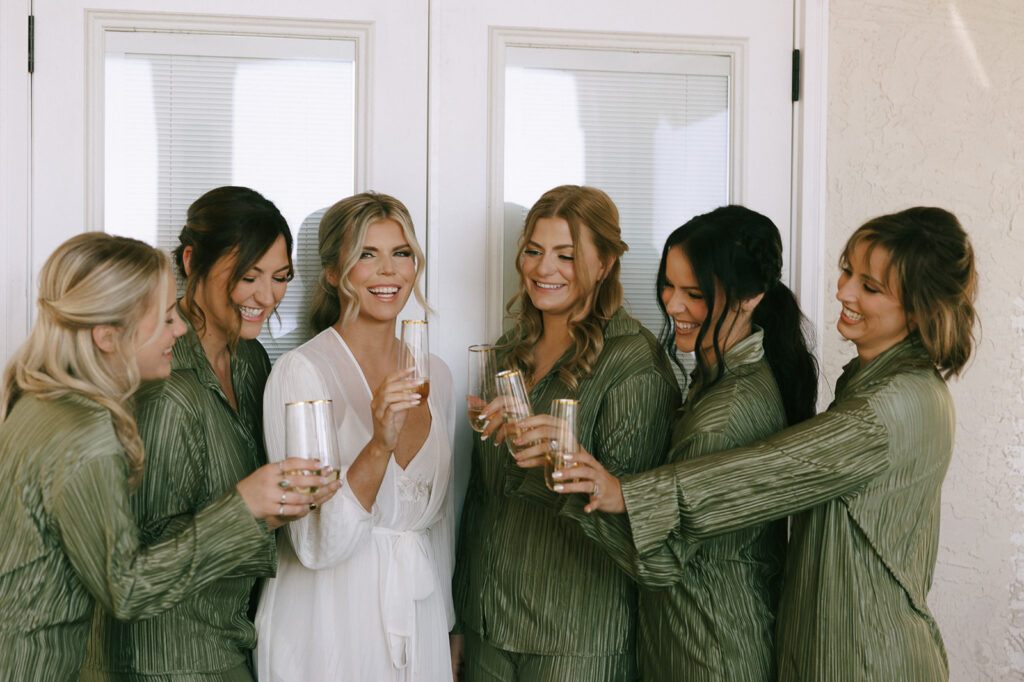 picture of the bride and her bridesmaids drinking champagne 