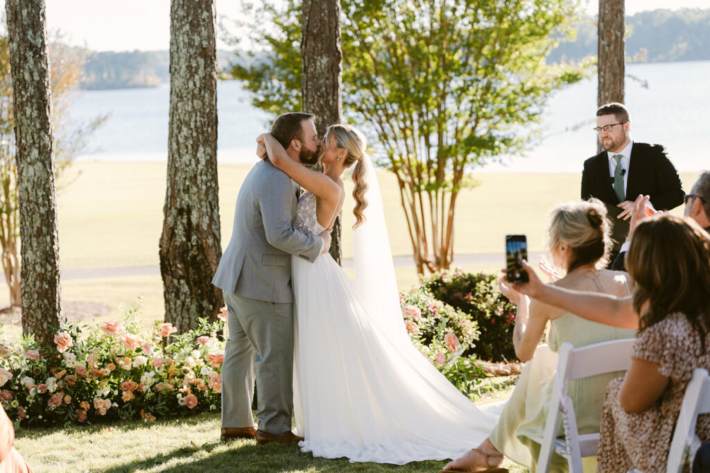 bride and groom kissing after their lake house wedding ceremony 