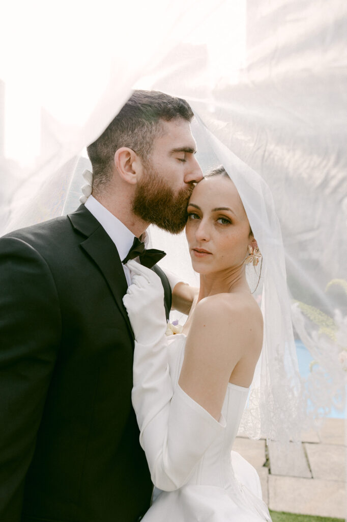 groom kissing the bride on the forehead 