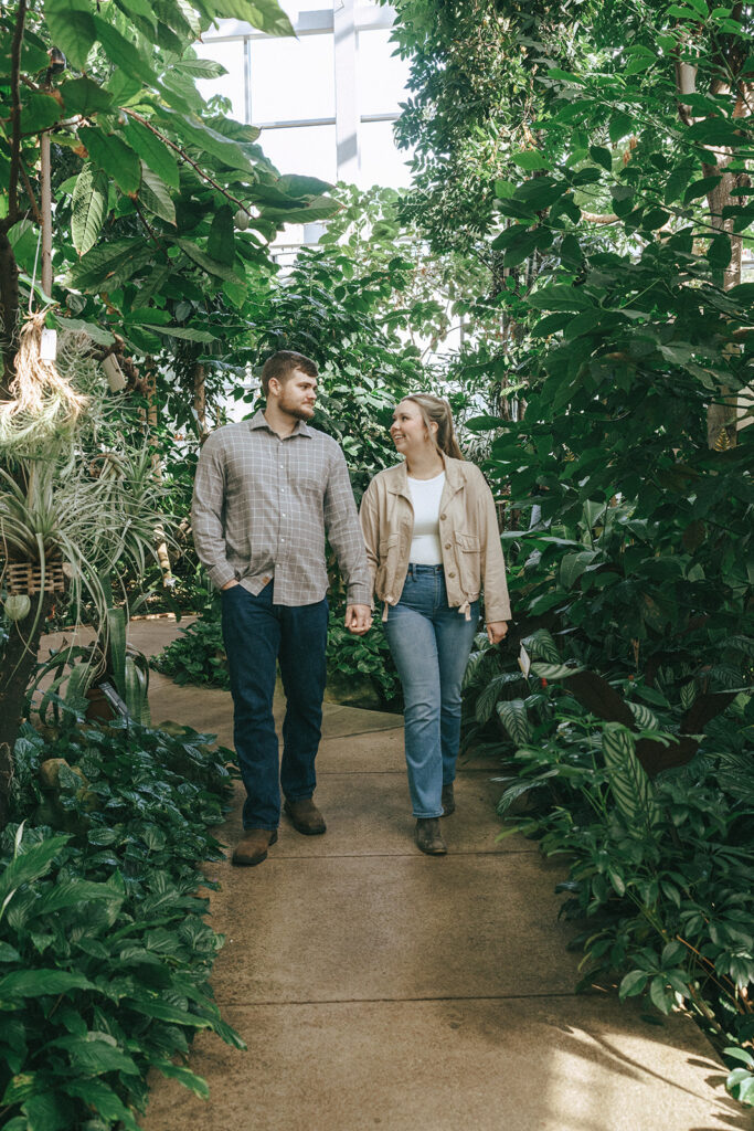 couple holding hands walking around their engagement location