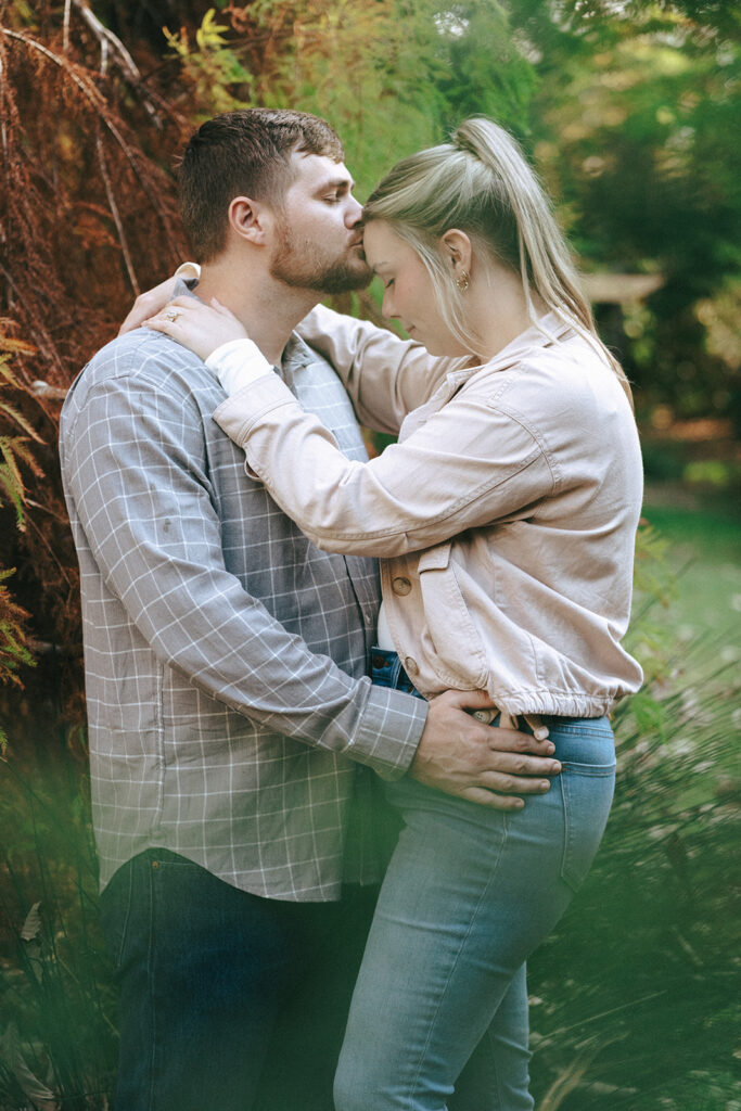 cute picture of the fiance kissing his fiance on the forehead 