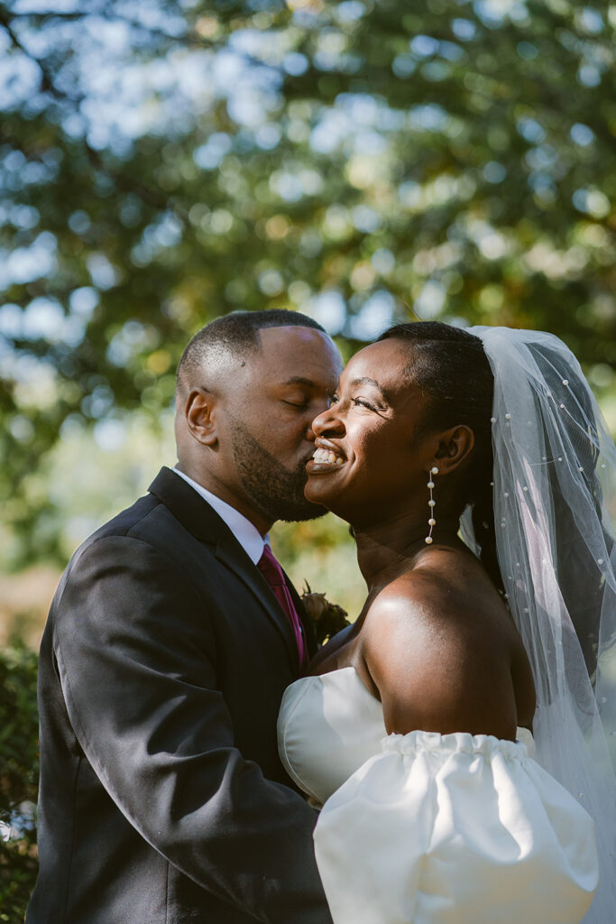 picture of the groom kissing the bride on the cheek