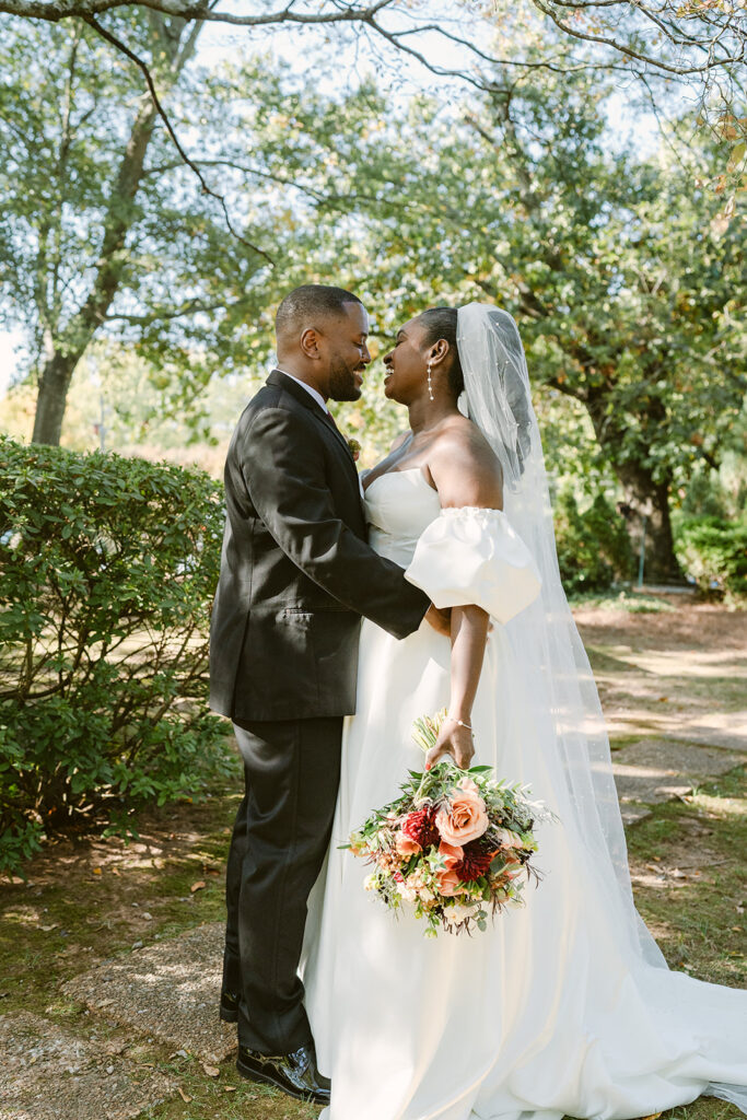 portrait of the couple laughing with each other at their fall garden wedding