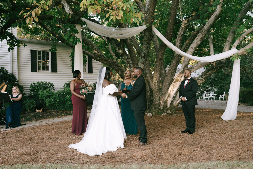 bride and groom holding hands during their ceremony 