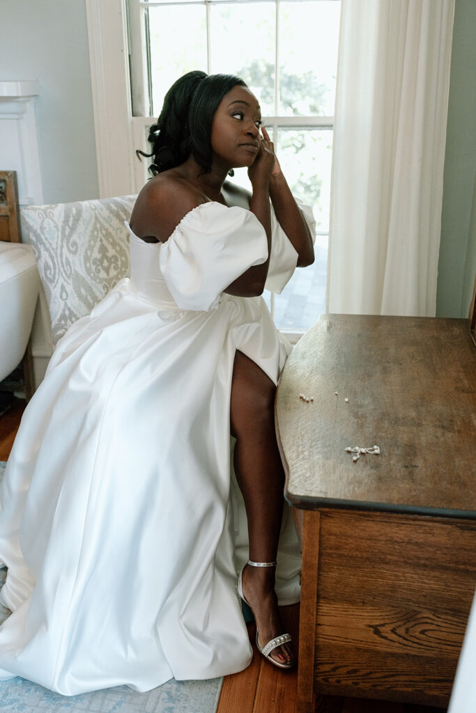 bride putting on her jewelry for her ceremony 