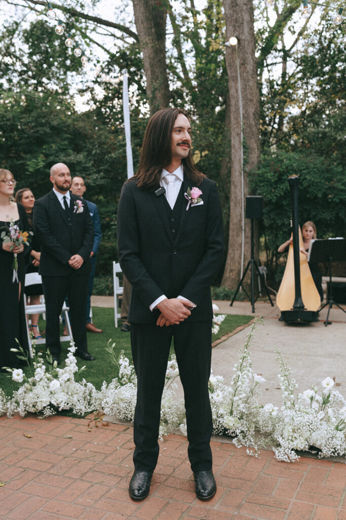 groom watching the bride walk down the aisle 