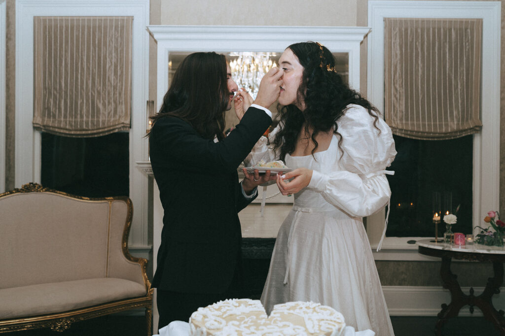 newly married couple trying their wedding cake at their reception party