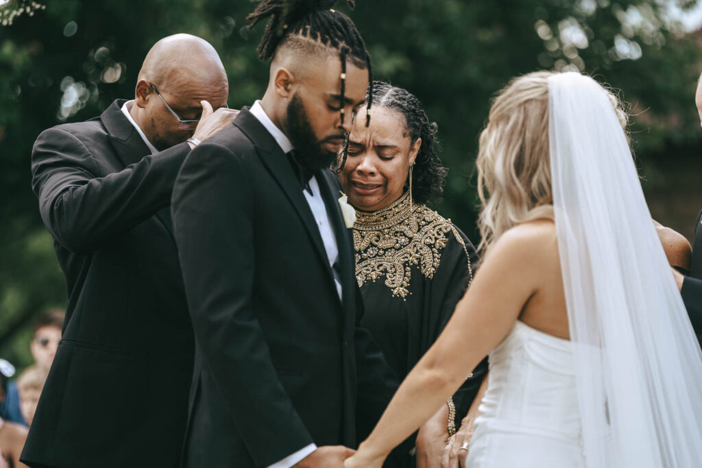 family of the bride and groom praying for them during their ceremony