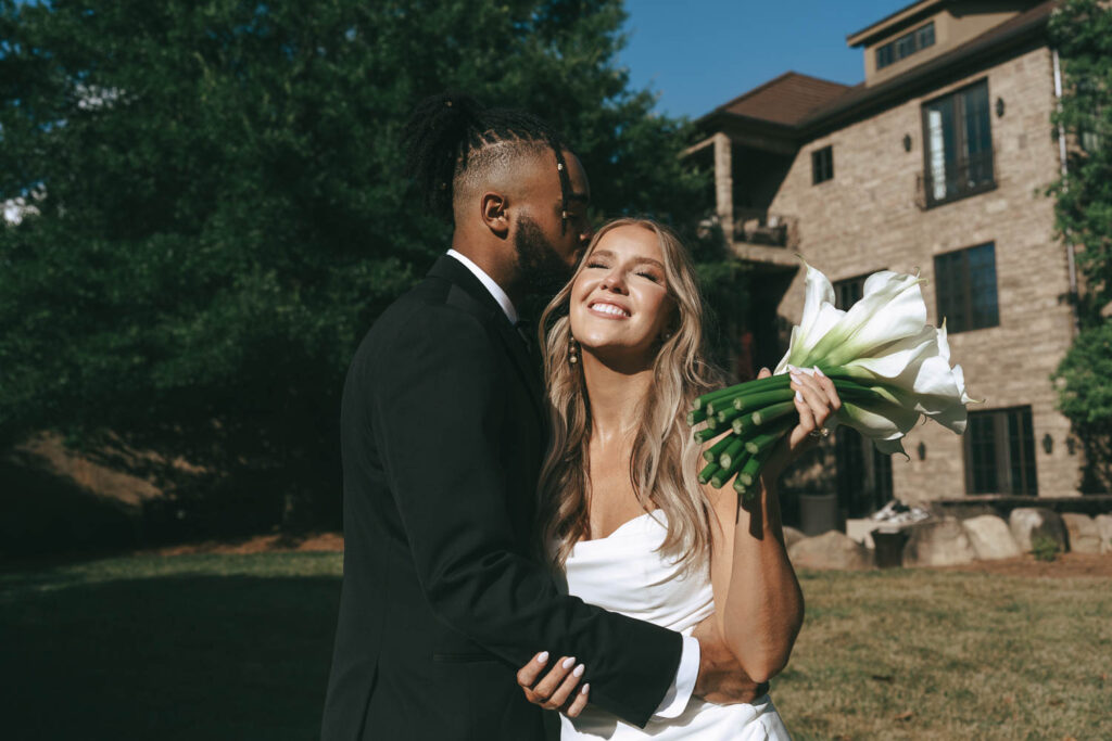 portrait of the groom kissing the bride on the cheek