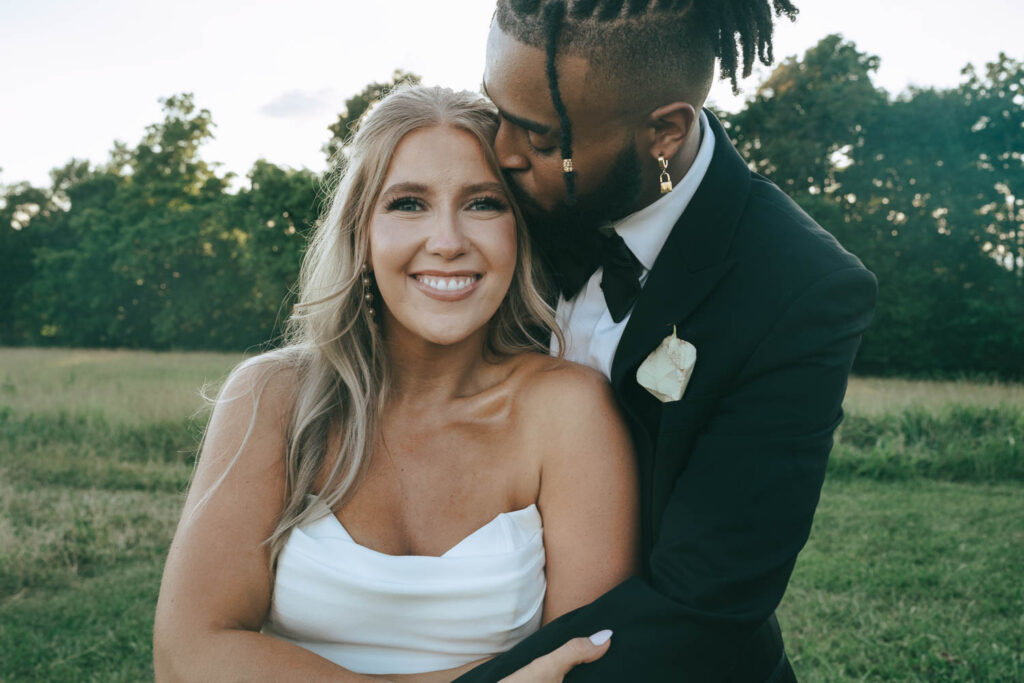 groom kissing the bride on the forehead 