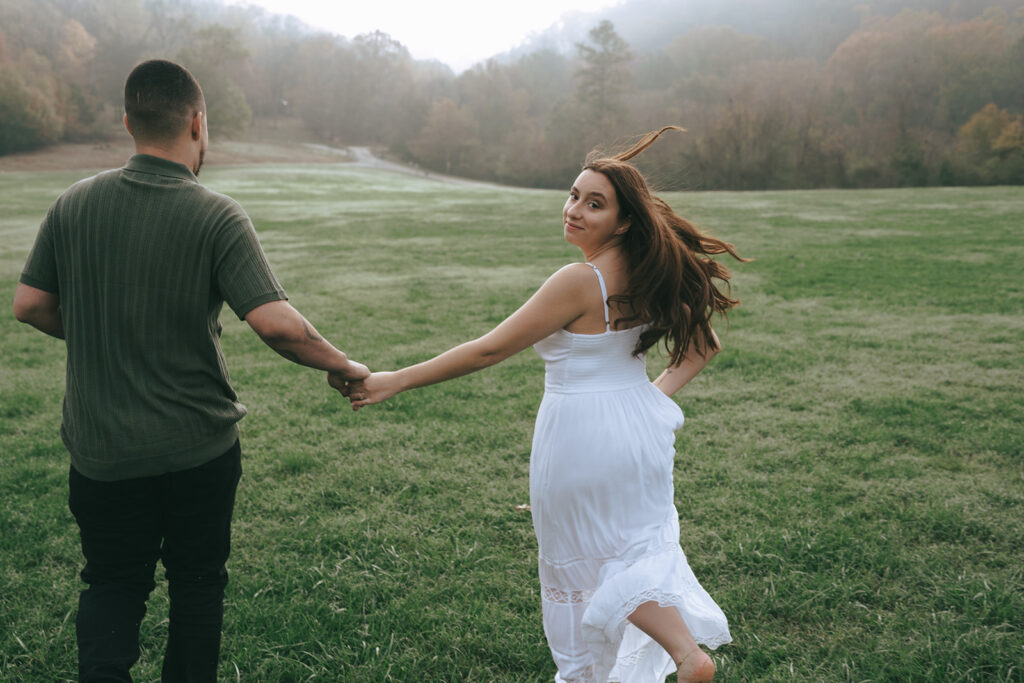 happy couple walking around the field during their photoshoot