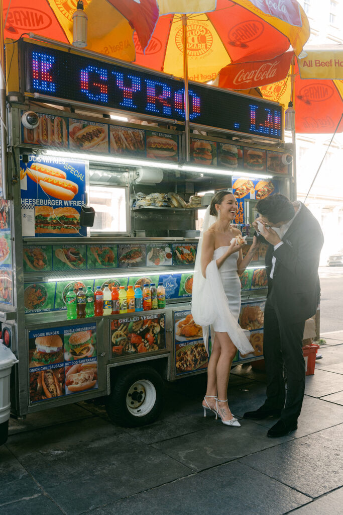 bride and groom eating a hot dog in NYC 