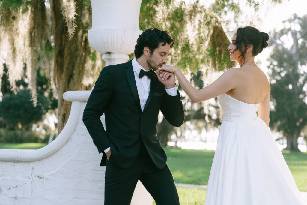 portrait of the groom kissing the bride hand