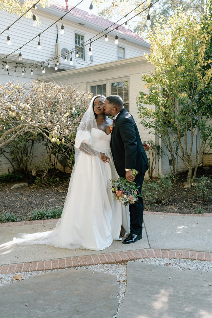 groom kissing the bride on the cheek