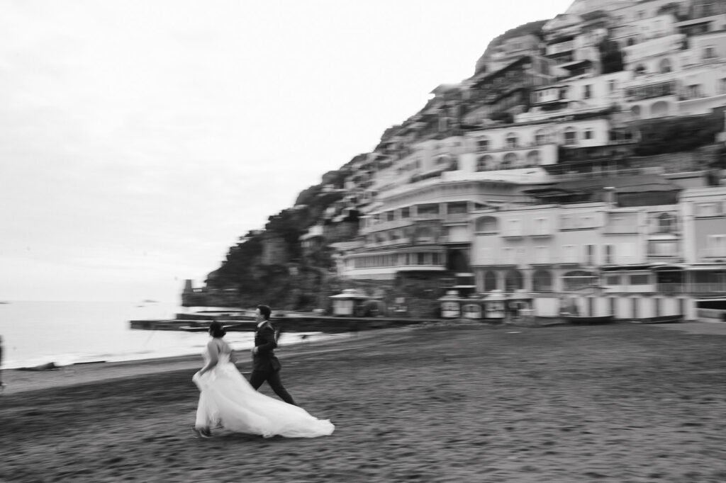 cute couple running around a beach in positano