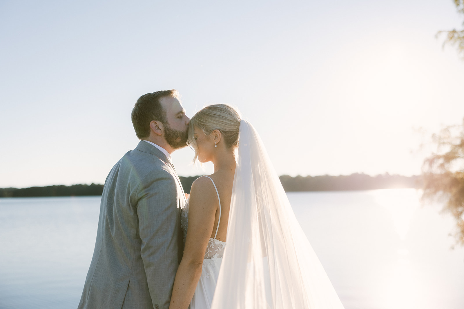 portrait of the groom kissing the bride on the forehead