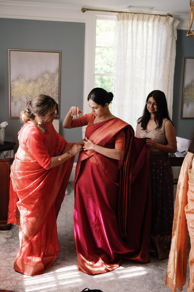 mother of the bride helping her with her wedding attire