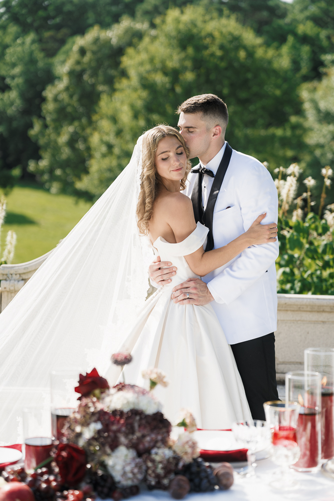 Groom, kissing the bride on the forehead