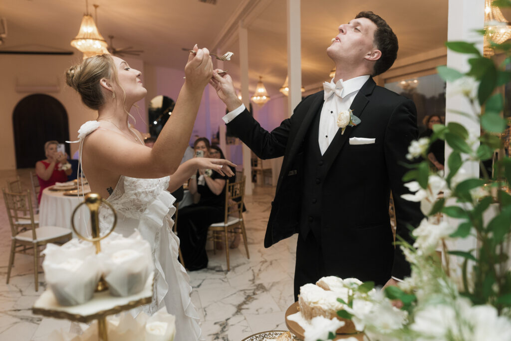 newlyweds trying their wedding cake