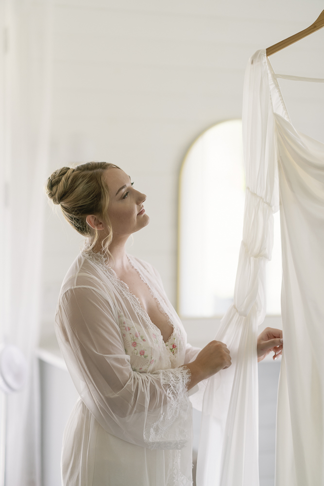 Cute picture of the bride next to her wedding dress