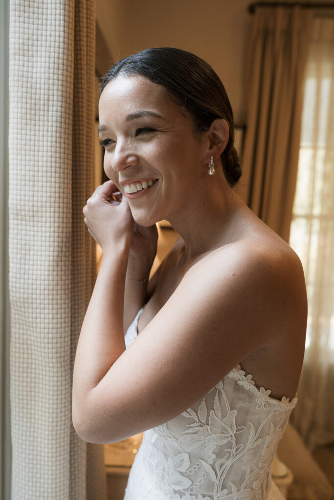 cute picture of the bride putting on her jewelry before the ceremony