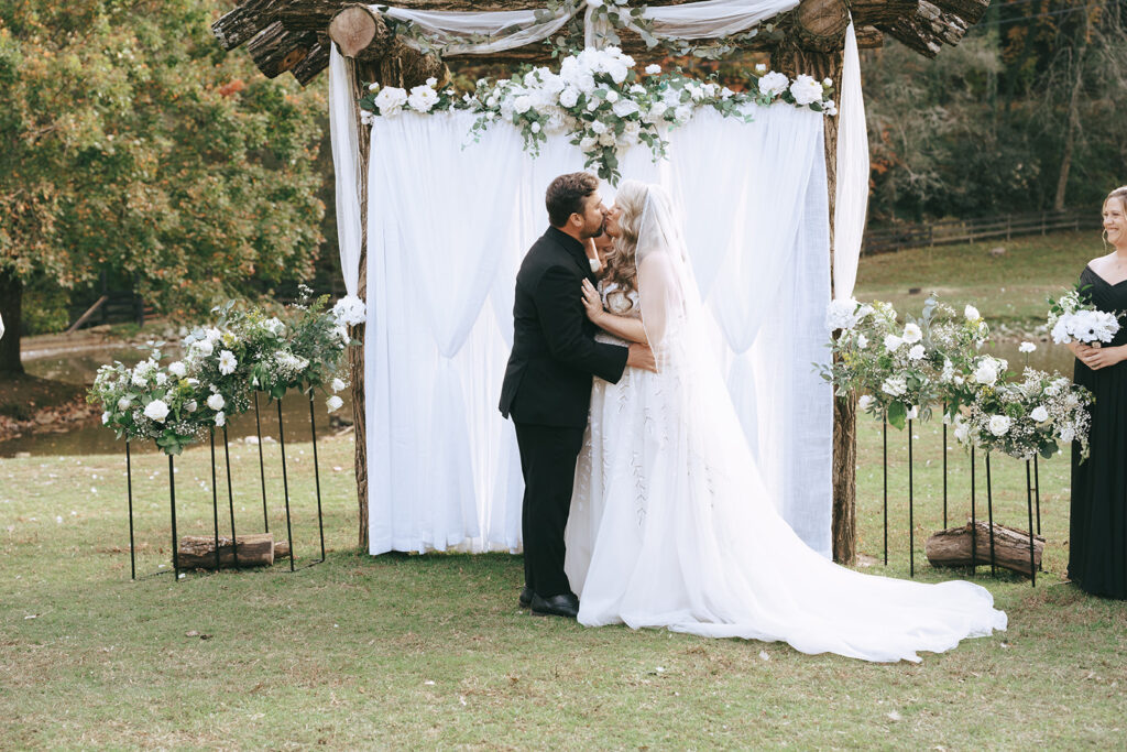 cute picture of the bride and groom kissing after their ceremony