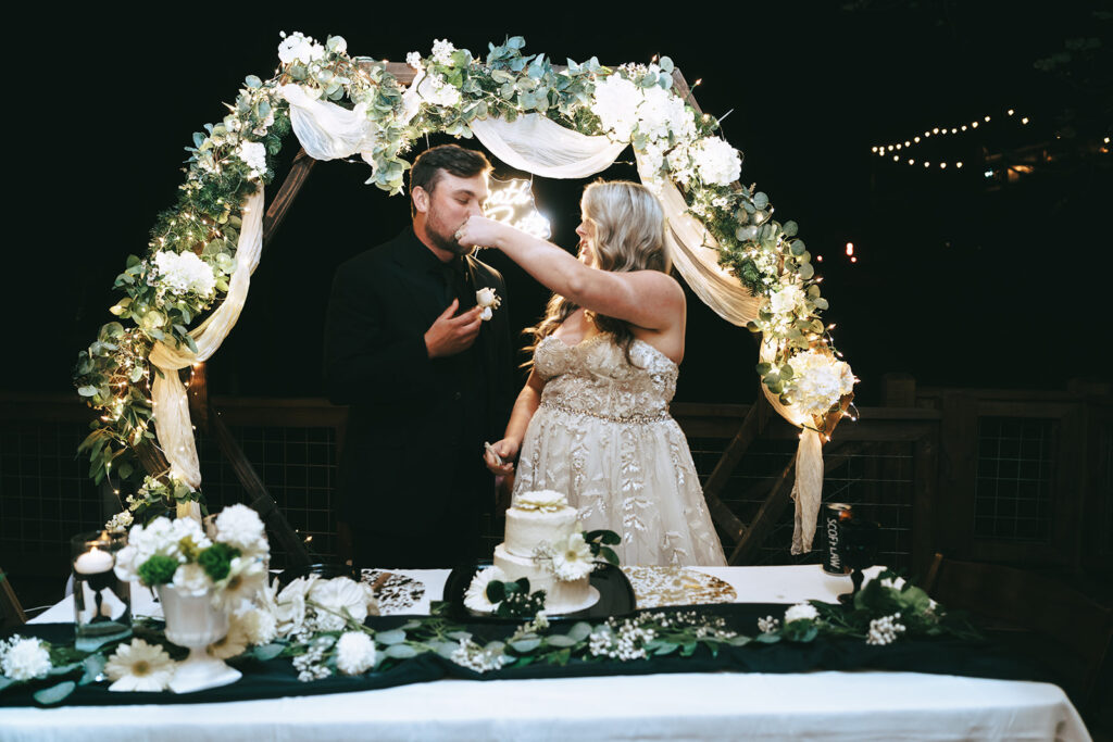 couple trying their wedding cake