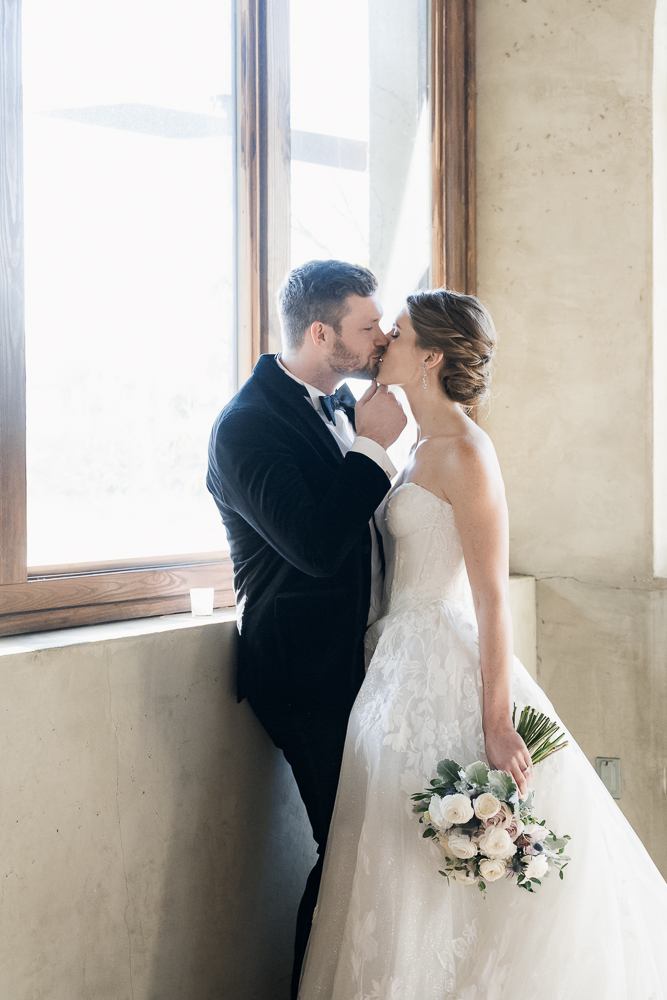 Cute portrait of the bride and groom kissing