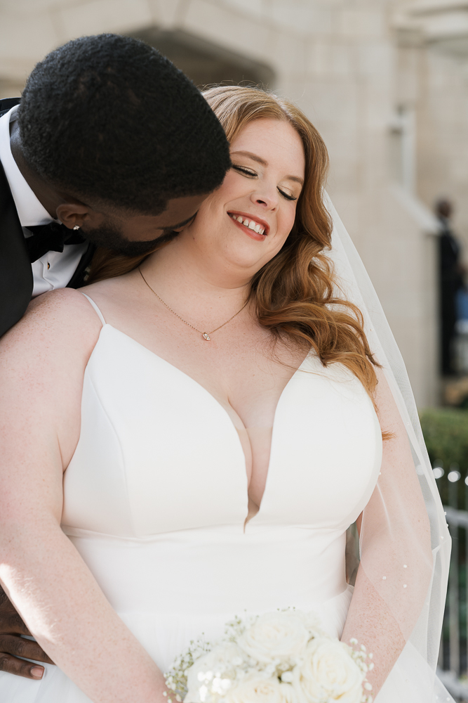 cute portrait of the groom kissing the bride on the cheek