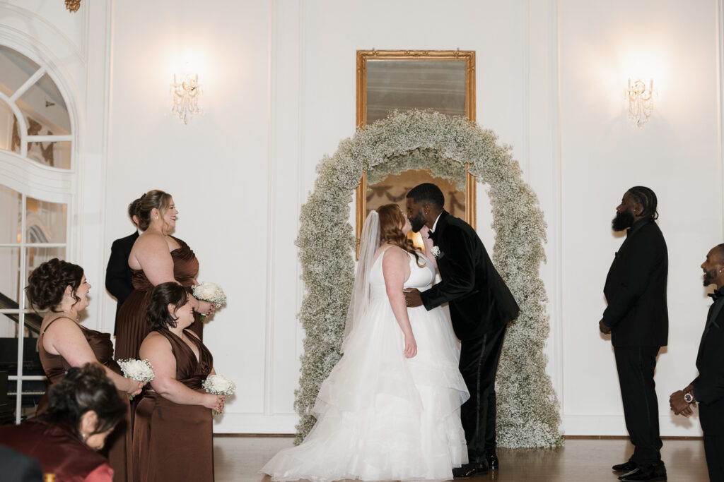 portrait of the bride and groom kissing after their wedding ceremony