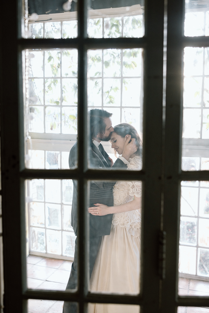 groom kissing the bride on the forehead