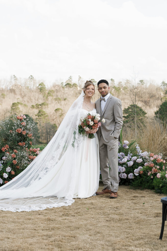bride and groom smiling at the camera during their photoshoot