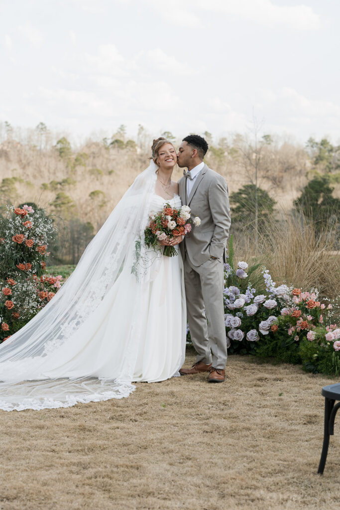 groom kissing the bride on the cheek