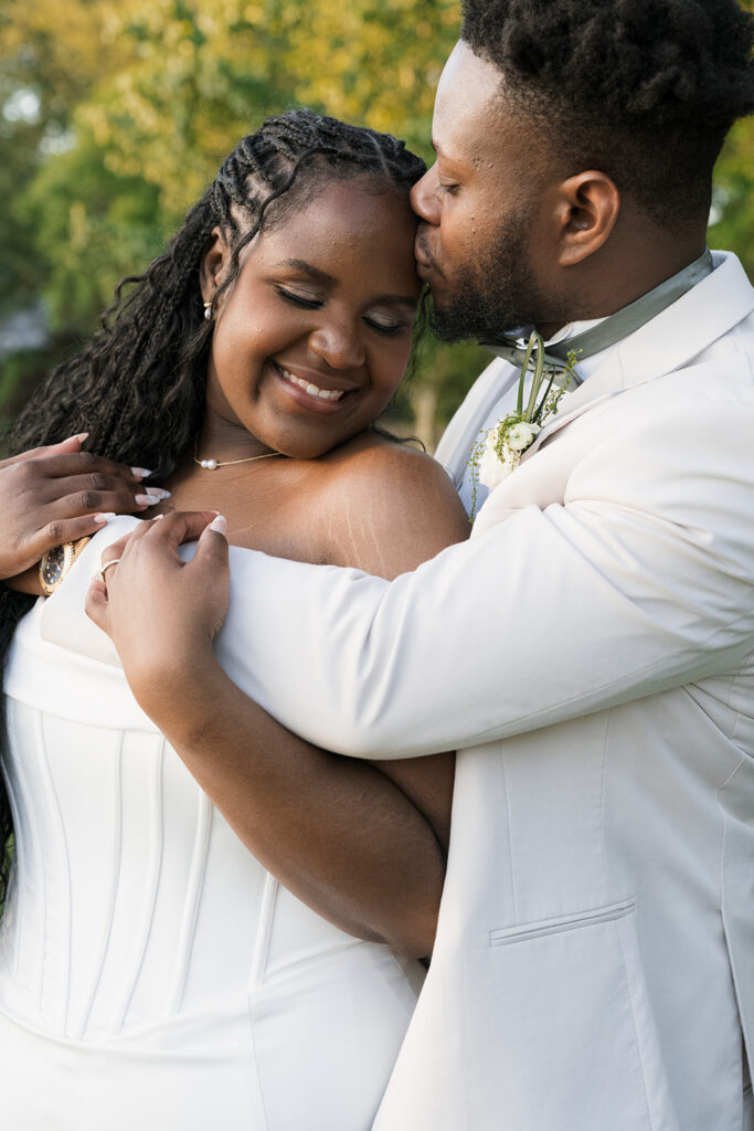 groom kissing the bride on the forehead